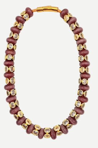 A beaded necklace featuring dark reddish-brown wooden beads set with clear round stones in gold-toned bezel settings, completed with a gold clasp, shown on a white background.