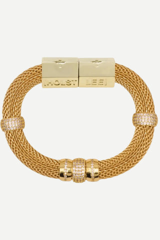 A gold-toned mesh bracelet with a rectangular clasp engraved with 'HOLST LEEI', accented by three bezel-set round crystal clusters on the lower arc and two smaller crystal accents on the opposite side.
